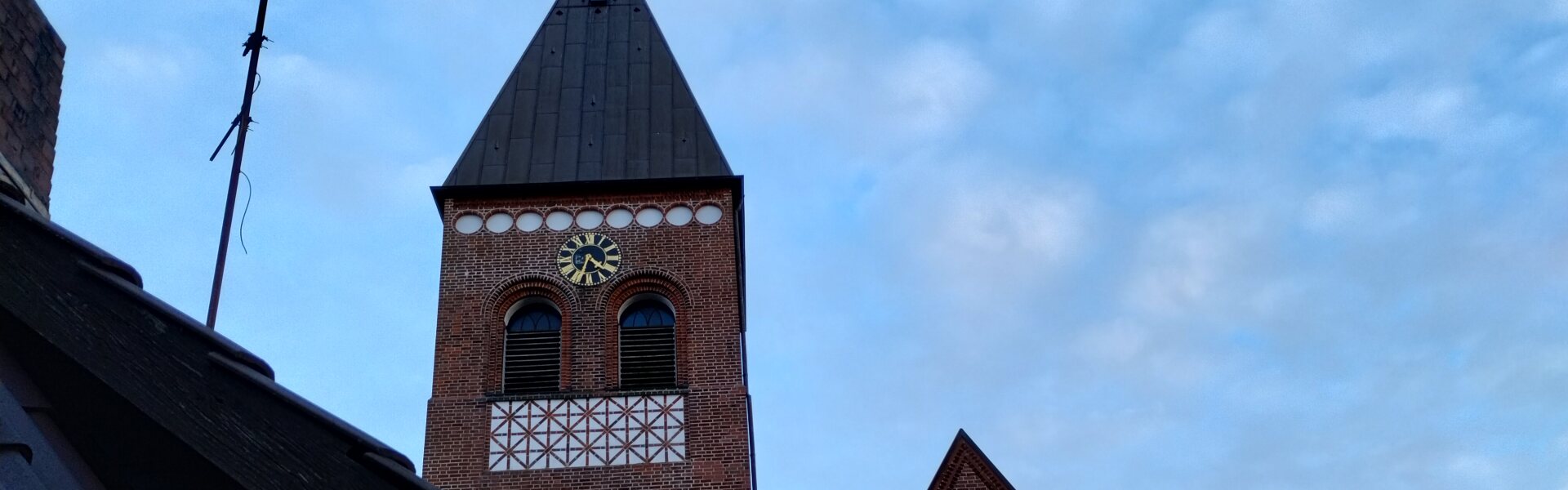 Kirchturm und Kirchenschiff aus dem Gemeindehaus-Dachfenster aus Richtung Westen